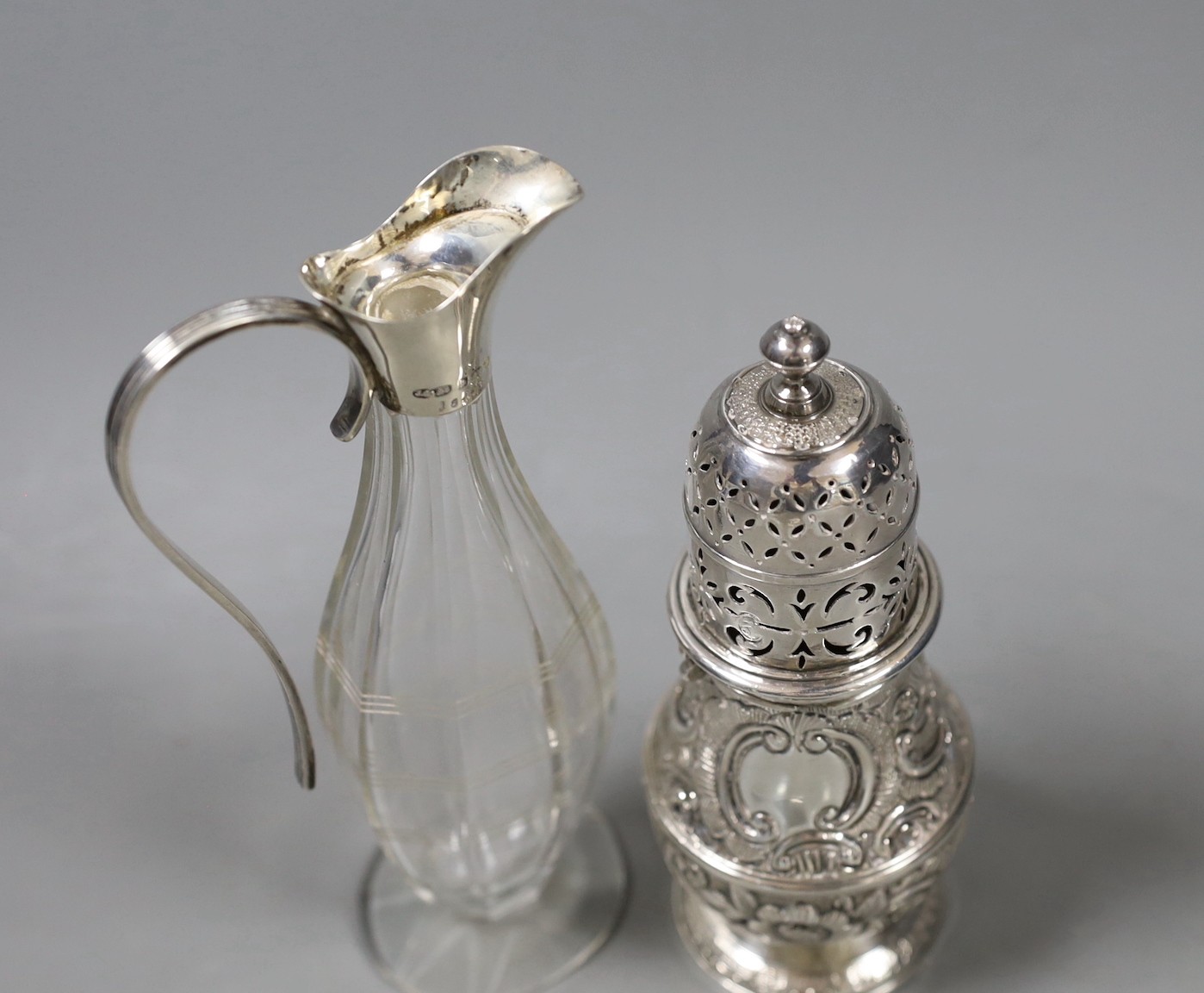 A continental white metal baluster caster (top and base associated), 14.2cm and a 1920's silver mounted condiment bottle.